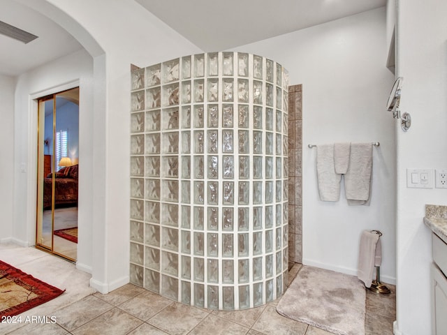 bathroom featuring vanity, a shower, and tile patterned flooring