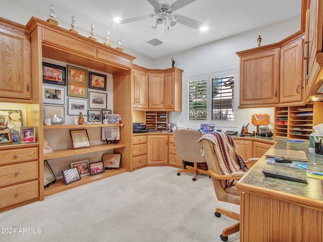 office area featuring ceiling fan, built in desk, and light carpet