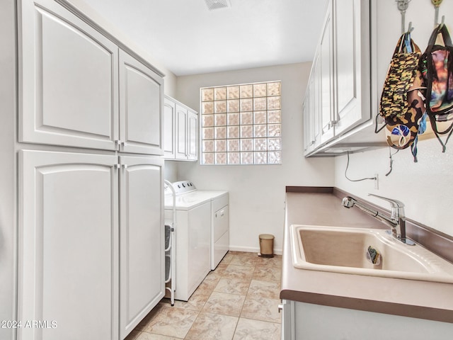 clothes washing area featuring cabinets, independent washer and dryer, and sink