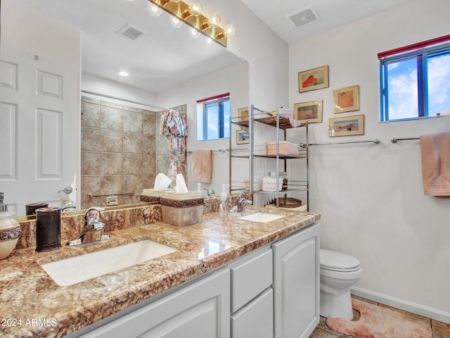 bathroom featuring vanity, toilet, tile patterned floors, and a wealth of natural light