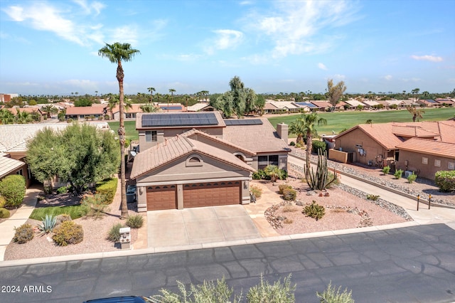 view of front of property with a garage and solar panels