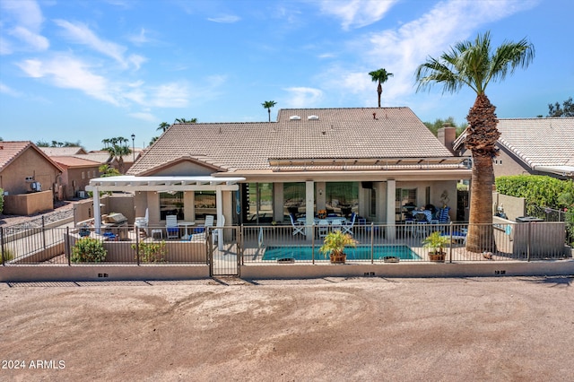 rear view of property with a patio and a fenced in pool