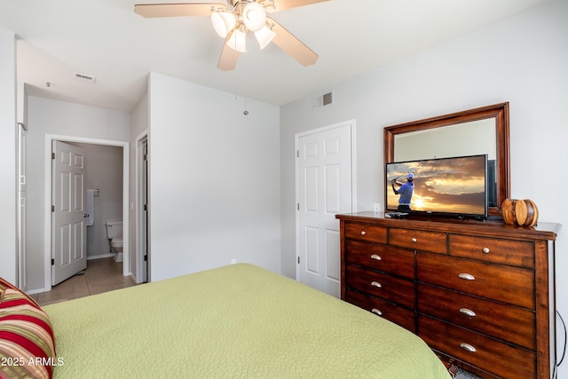bedroom featuring tile patterned floors, connected bathroom, baseboards, and a ceiling fan