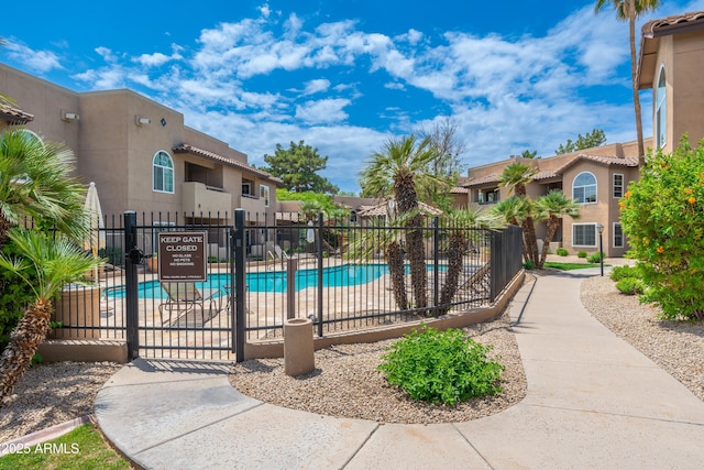 community pool with fence and a residential view