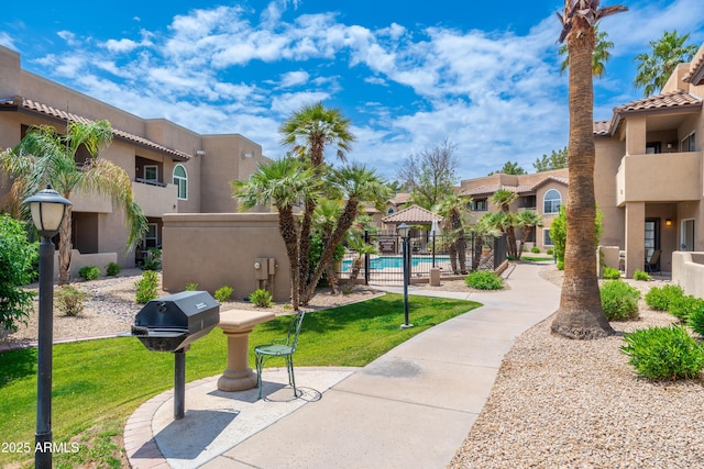 surrounding community with a swimming pool, a residential view, and a gazebo