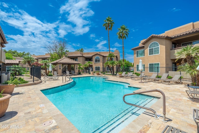 community pool with a gazebo, a patio, and fence