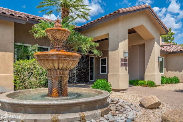 exterior space featuring a tile roof and stucco siding