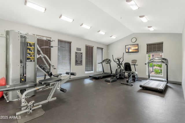 workout area featuring vaulted ceiling and baseboards