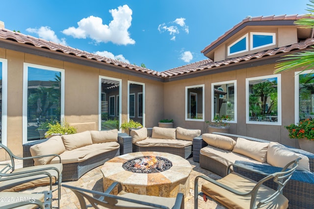 view of patio with an outdoor living space with a fire pit