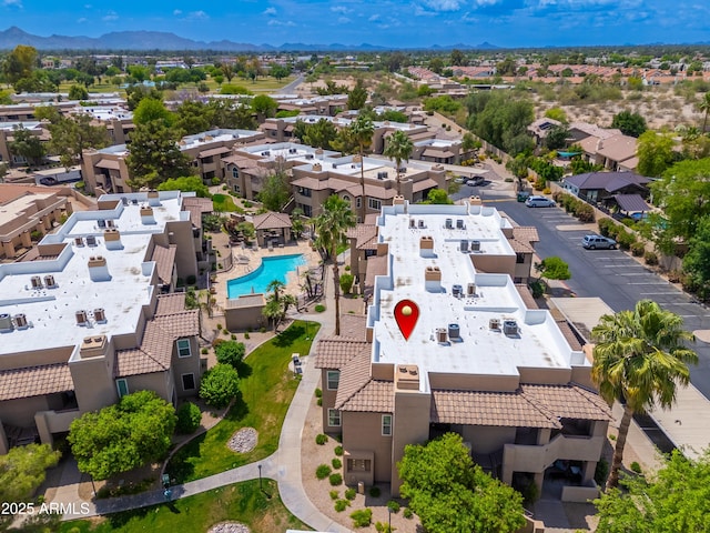 aerial perspective of suburban area with a pool and a mountain backdrop