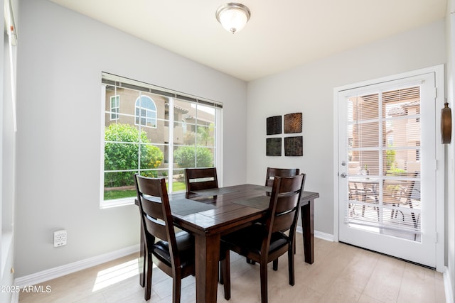 dining space featuring baseboards and light wood-style floors