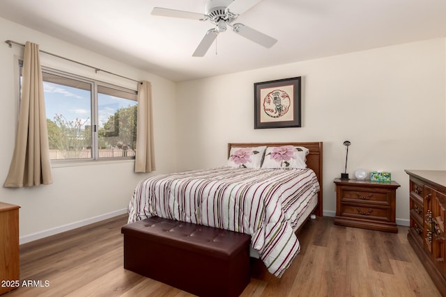 bedroom featuring wood finished floors, a ceiling fan, and baseboards