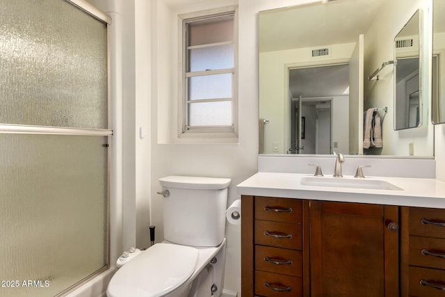 bathroom featuring vanity, visible vents, an enclosed shower, and toilet
