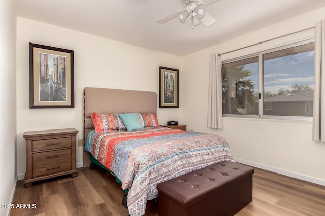 bedroom featuring ceiling fan, baseboards, and wood finished floors