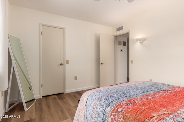 bedroom featuring visible vents, baseboards, and wood finished floors