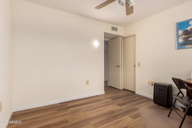 office space featuring wood finished floors, baseboards, a ceiling fan, and visible vents