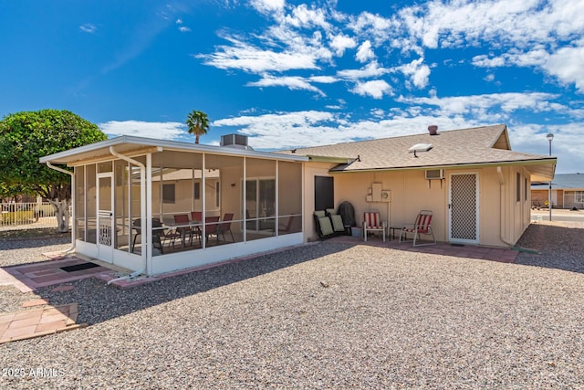 rear view of property featuring a sunroom, fence, and a patio