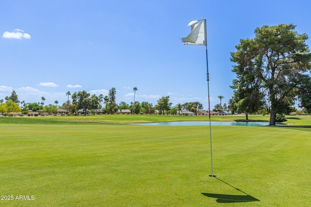 view of home's community featuring a yard, view of golf course, and a water view