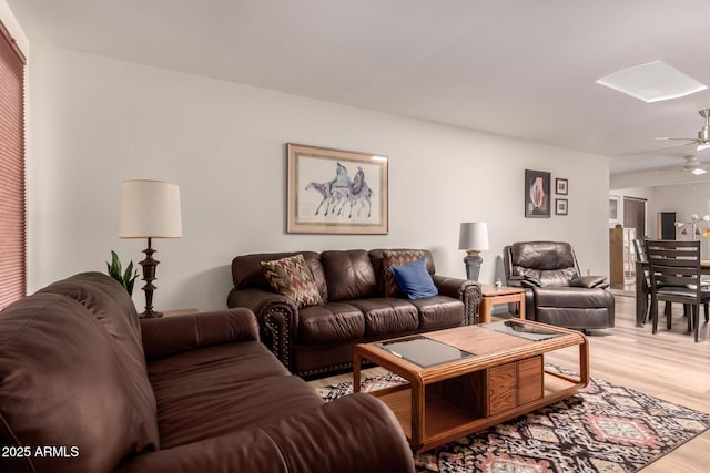 living area featuring light wood-type flooring and ceiling fan