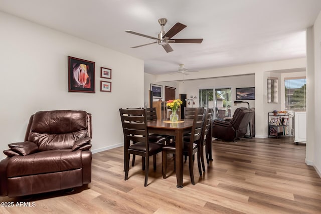 dining area featuring light wood finished floors, baseboards, and ceiling fan