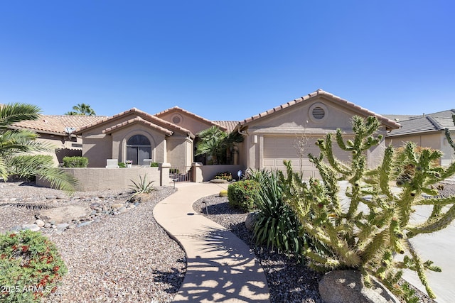 9216 E Rocky Lake Dr, Sun Lakes, AZ 85248 - mediterranean / spanish home featuring stucco siding, a fenced front yard, a gate, a tile roof, and an attached garage