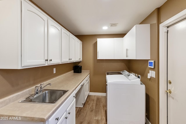 9216 E Rocky Lake Dr, Sun Lakes, AZ 85248 - washroom with cabinet space, light wood-type flooring, washing machine and dryer, visible vents, and a sink