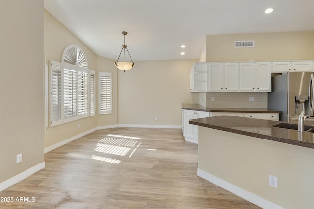9216 E Rocky Lake Dr, Sun Lakes, AZ 85248 - kitchen with open shelves, white cabinets, visible vents, stainless steel refrigerator with ice dispenser, and backsplash