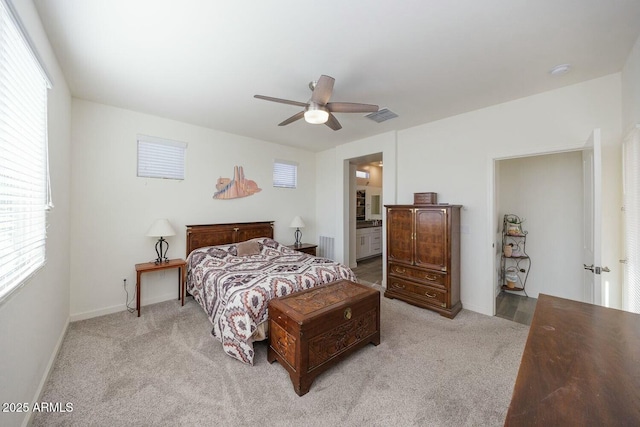 carpeted bedroom with ensuite bathroom and ceiling fan