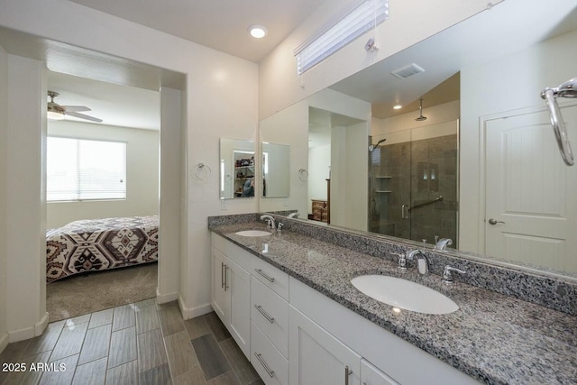 bathroom featuring ceiling fan, a shower with door, and vanity