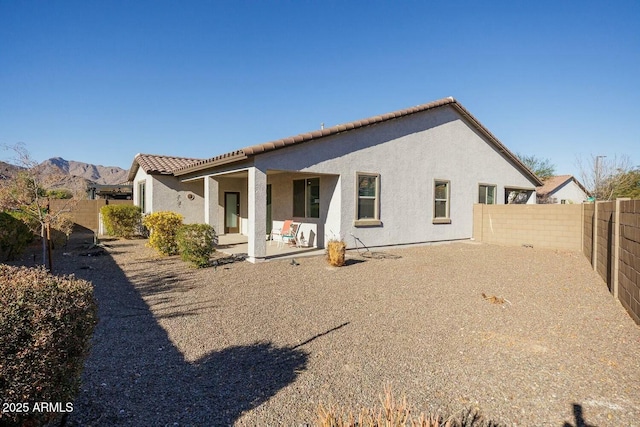 back of property featuring a mountain view and a patio area