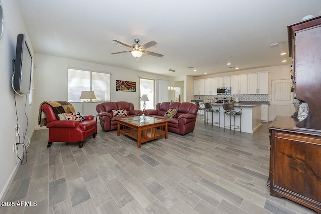 living room with ceiling fan and light hardwood / wood-style floors