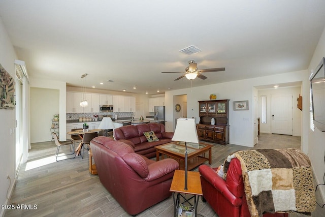 living room featuring light hardwood / wood-style floors and ceiling fan