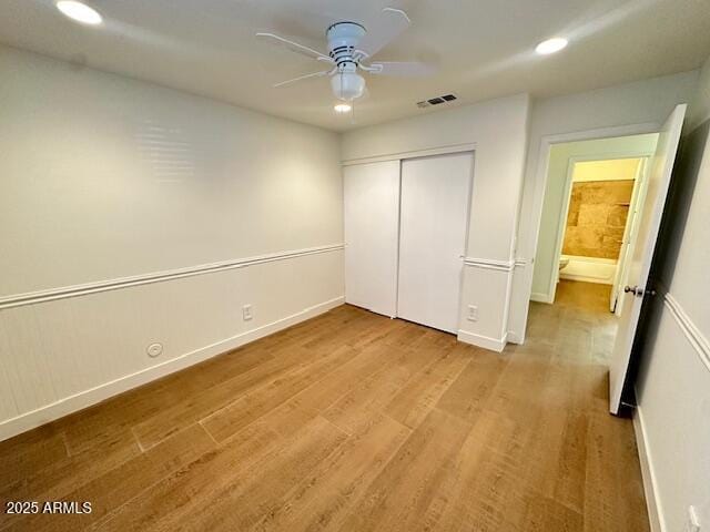 unfurnished bedroom featuring a closet, ceiling fan, and light wood-type flooring