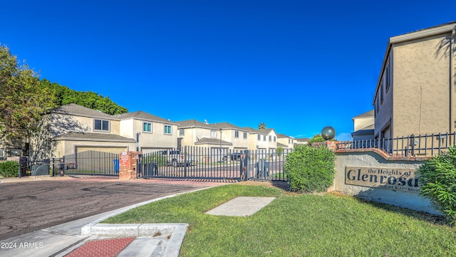 exterior space with a gate, curbs, a residential view, and a gated entry