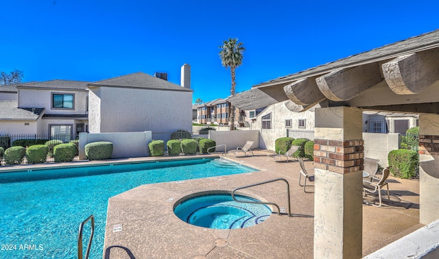 community pool featuring a patio, fence, a residential view, and a hot tub