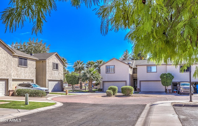 view of front of property with stucco siding, driveway, and a garage