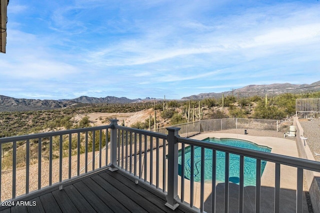 wooden terrace featuring a mountain view and a fenced in pool