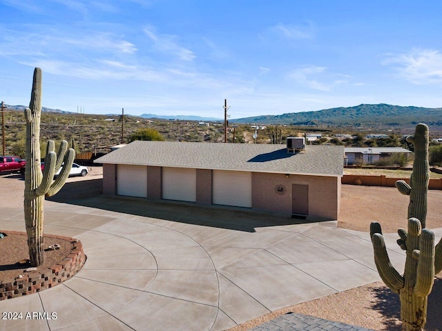 view of front of property featuring a mountain view, a garage, and central AC