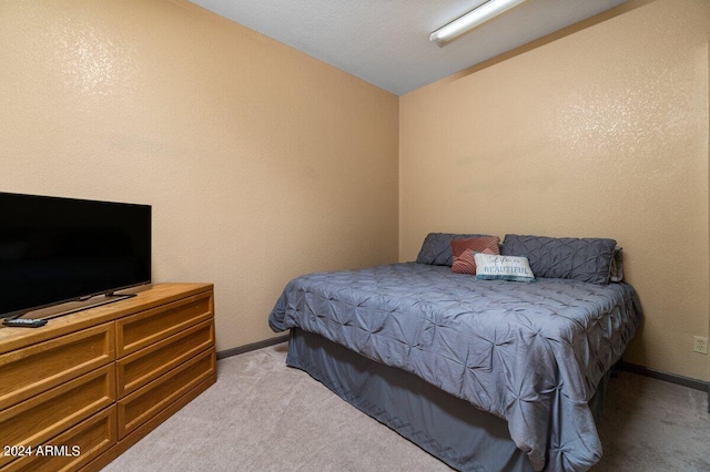 carpeted bedroom with lofted ceiling