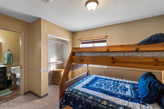 carpeted bedroom featuring a textured ceiling, a closet, and connected bathroom