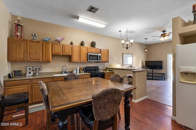 kitchen featuring a textured ceiling, dark wood-type flooring, sink, white refrigerator with ice dispenser, and electric range