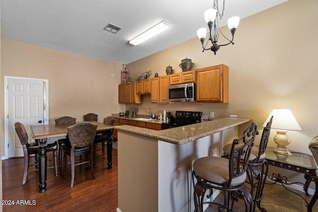 kitchen with sink, dark wood-type flooring, black range with electric cooktop, kitchen peninsula, and a chandelier