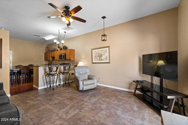 living room with ceiling fan with notable chandelier