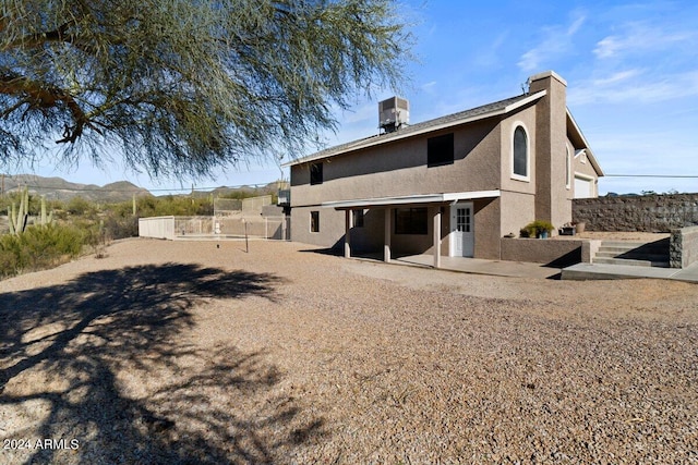 back of property with a mountain view and central air condition unit