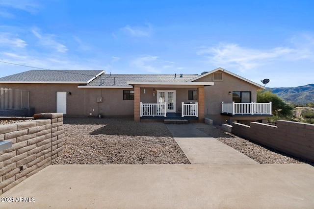 rear view of property featuring a mountain view and a porch