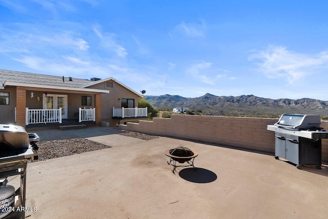 view of patio / terrace with a mountain view, a grill, and an outdoor fire pit