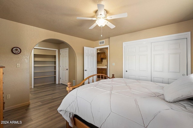 bedroom featuring a textured ceiling, a closet, dark hardwood / wood-style floors, and ceiling fan