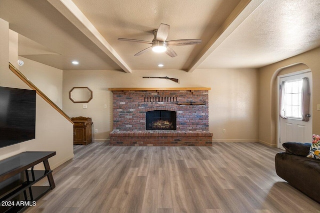 living room featuring beam ceiling, a textured ceiling, and hardwood / wood-style flooring