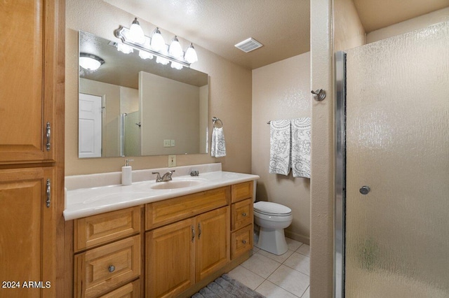 bathroom with vanity, tile patterned floors, toilet, a textured ceiling, and an enclosed shower