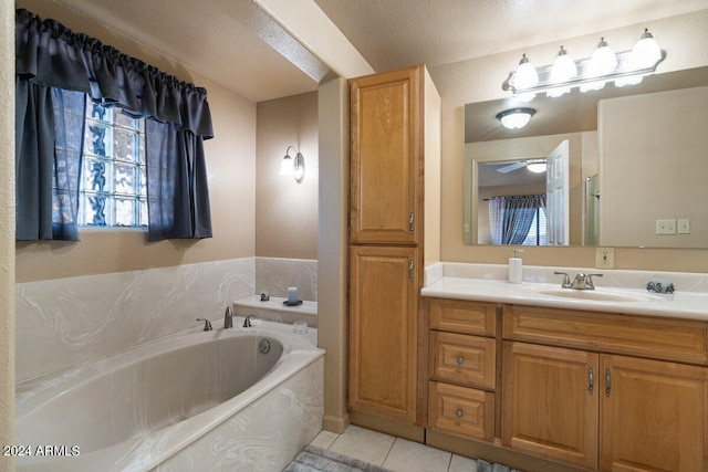 bathroom with tile patterned flooring, vanity, a textured ceiling, and a bathtub